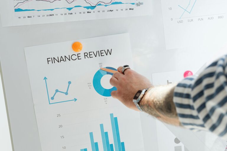 Close-up of a hand pointing to financial charts during a business review.